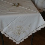 Touch of Gold tablecloths & Doilies features beautifully embroidered Candles with gold thread embroidered Ribbons & Hearts on Ecru easy care Viscose & Polyester blend. Full hand crocheted lace edge.