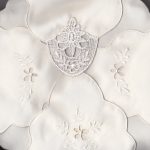 Close-up of the Macramé Lace Bun Warmer Cover, featuring ivory lace linen with delicate floral embroidery and layered design for a soft, elegant look.
