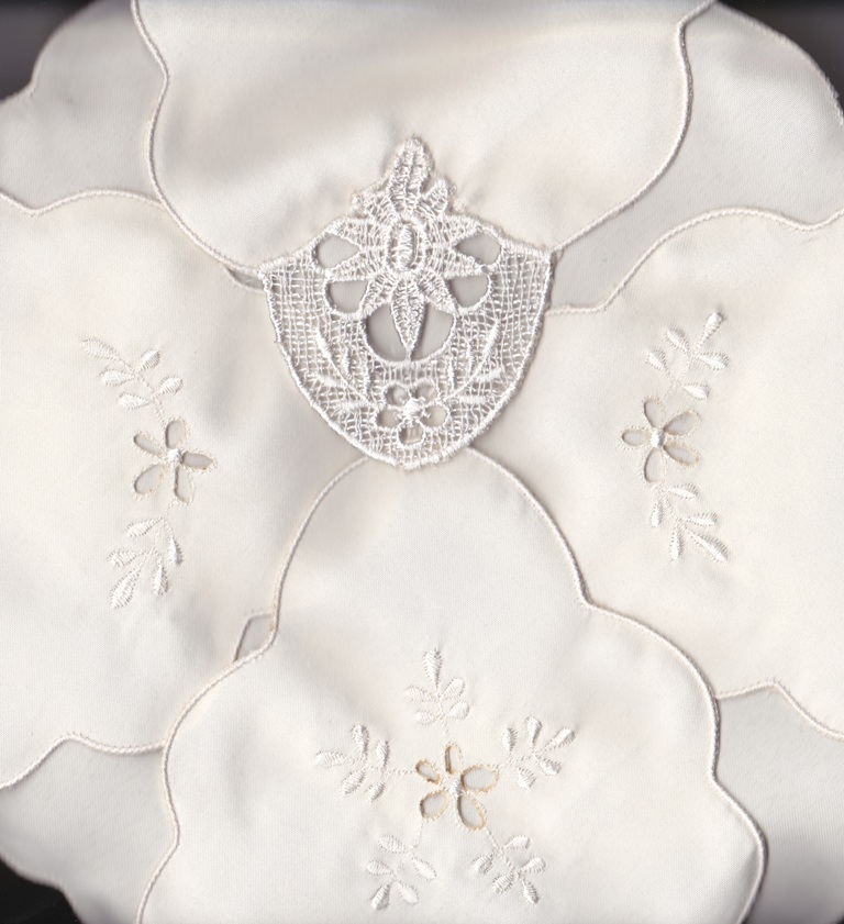 wMacrame-Lace-Ecru-433 Close-up of the Macramé Lace Bun Warmer Cover, featuring ivory lace linen with delicate floral embroidery and layered design for a soft, elegant look.