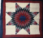 Introducing the Tartan Lone Star Quilted Tablecloth & Wall Hanging, featuring an intricate eight-pointed star design crafted with plaid fabric in shades of red, gray, and black on a cream background. The star is elegantly framed with maroon and dark blue fabric strips.