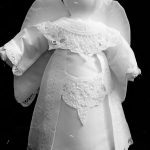 A black and white image of a cloth Tree Top Angel with lace details on its wings and dress. Wool felted Hair. Victorian style timeless Doll.