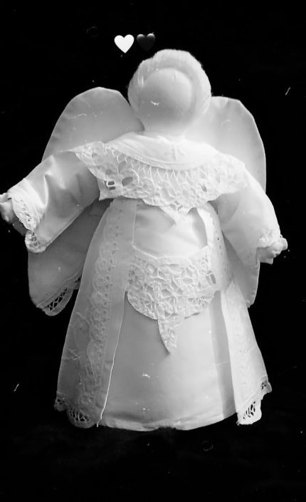 A black and white image of a cloth Tree Top Angel with lace details on its wings and dress. Wool felted Hair. Victorian style timeless Doll.