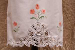 Close up view of Peach or Coral embroidered Tulips on the apron. Battenburg Lace shaped like tulips is more pronounced.