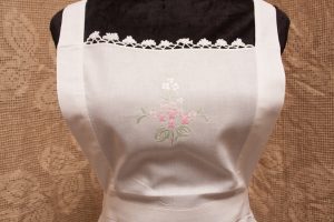 Close up of the bib shows the details of the exquisite embroidery and the crocheted lace trim.