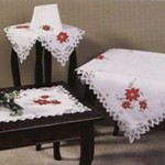 Elegant Christmas tablecloth with applique red poinsettias and Battenburg lace fully edged. Premium quality pure white cotton. Available in 7 sizes .