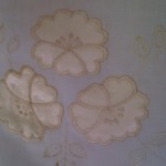 The play of light on quality satin appliqué primrose with a light Touch of Gold.
