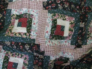Traditional patchwork Flower Patch Log Cabin with hand quilting. Cotton fabric with polyester filling.