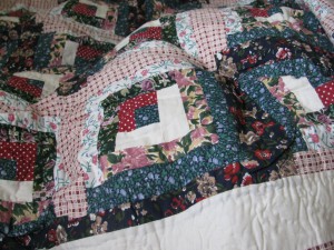 Traditional patchwork Flower Patch Log Cabin with hand quilting. Cotton fabric with polyester filling.