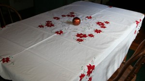 Appliqué Red Poinsettia with Battenburg Lace on pure white cotton sets a cheerful tone to a festive holiday celebration.