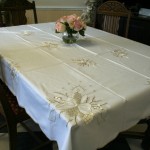Golden Moments tablecloth beautifully embroidered white candles with gold thread accents on easy care Viscose & Polyester blend.