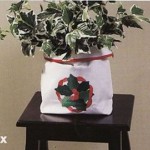 Applique Holly Wreath Gift Bag as indoor plant holder.