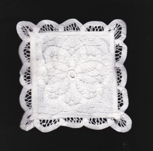 Handmade Battenburg Lace square tea coasters with White 100% Cotton lining. A closeup view.
